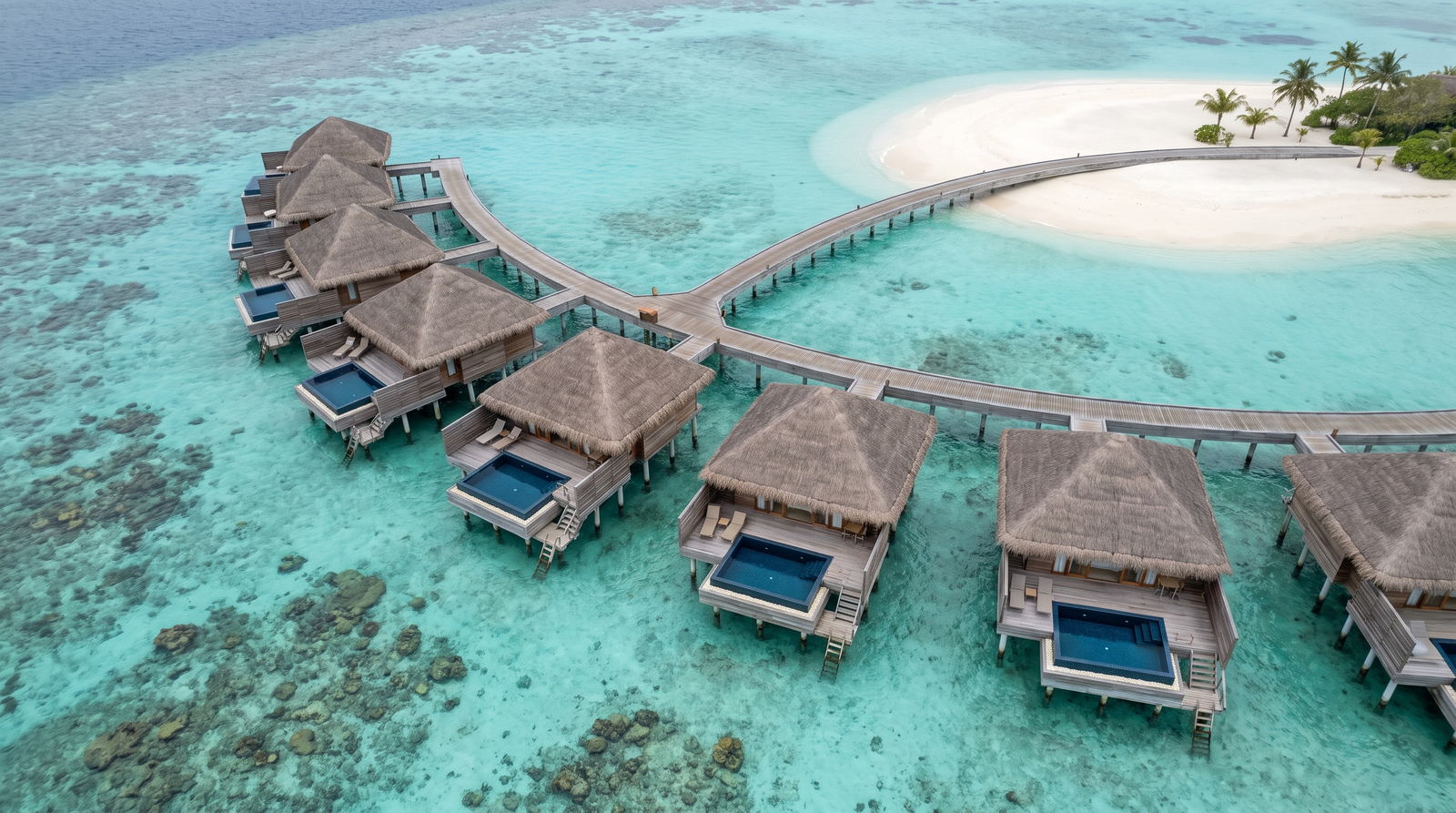 Aerial view of an overwater villa resort above a turquoise lagoon